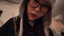 a close up of a woman wearing glasses and a hat with byulbaen written in the corner
