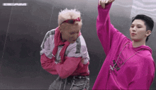 a man wearing a pink sweatshirt that says beam on it