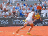 a man playing tennis on a court with a sign that says infosys
