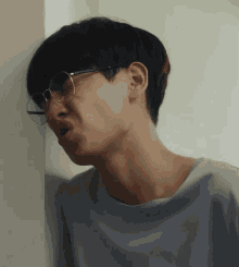 a young man wearing glasses is making a face