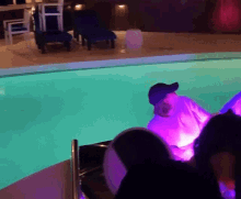 a man in a blue hat sits in a swimming pool