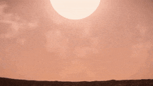 a futuristic space ship is silhouetted against a sunset sky