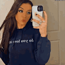 a woman is taking a picture of herself in a mirror with her phone