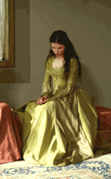 a woman in a green dress is sitting on a bench