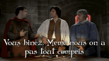three men are standing around a table with the words " vous binez meme nous on a pas tout compris " on the bottom