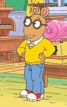 a cartoon character wearing glasses and a yellow sweater is standing with his hands on his hips .