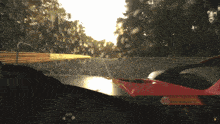 a red car is driving down a road with a sticker on the windshield that says gt