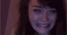 a close up of a woman 's face with tears running down her cheeks .