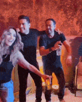 two men and a woman are dancing together in a dark room