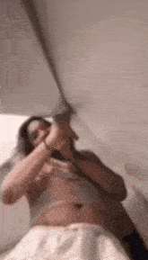 a woman is laying on a bed under a canopy and holding a sword .