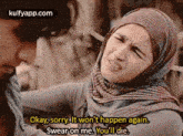 a woman in a hijab is swearing on a man .
