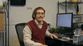 a man sitting at a desk with a computer that says google on the screen