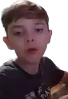 a young boy wearing a black t-shirt with the word play on it is making a funny face .