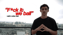 a man stands in front of a sign that says f * ck it we ball