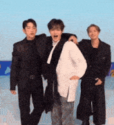 three men in suits are standing next to each other on a ice rink .