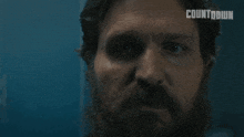 a man with a beard is looking at the camera with the word fuck below him