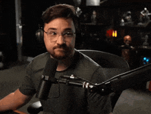 a man wearing headphones and glasses is sitting in front of a microphone