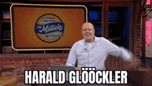 a man is sitting in front of a sign that says harald gloockler .