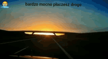 a sunset with the words bardzo mocno placesz drogo on the bottom right