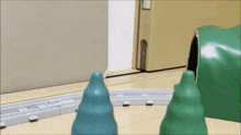 a toy train set with a tunnel and trees on the tracks .