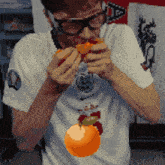 a man wearing glasses and a nike shirt is eating a tomato