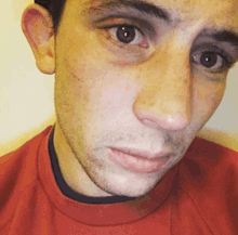 a close up of a man 's face wearing a red sweater