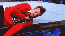 a man in a red shirt with the letter u on it is laying on the ground