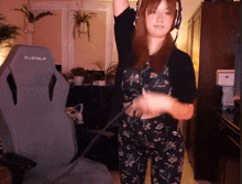 a woman wearing headphones is dancing in front of a chair that says quersus on it