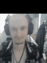 a man with a beard is wearing headphones and a floral shirt .