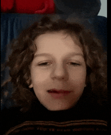 a young boy with curly hair is wearing a sweater that says you 've been waitin ' for