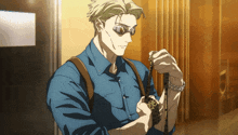 a man wearing sunglasses and a blue shirt is holding something