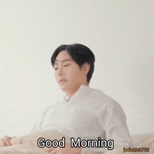 a man in a white shirt is stretching his arms and says good morning on the bottom