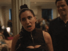 a man and a woman are standing next to each other and the woman is making a funny face