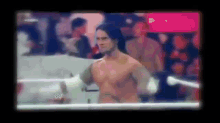 a man without a shirt is standing in a boxing ring