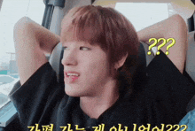 a young man sitting in a car with a question mark on his face
