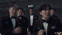 a group of men in tuxedos and bow ties are standing in front of a netflix sign