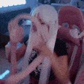 a woman in a white wig is sitting in a pink chair that says grizzly bear