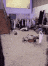 a very messy room with a lot of clothes on the floor and stairs .
