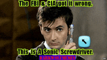 a man in a suit is holding a sonic screwdriver in his right hand