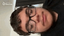 a man wearing glasses and a black shirt with the words made with revive on the bottom