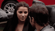 a man and a woman are looking at each other in a convertible