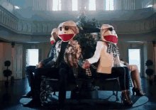 a group of people wearing sock monkey masks are sitting around a table