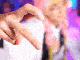 a person with pink hair is making a heart shape with their finger