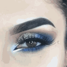 a close up of a woman 's eye with blue eyeshadow