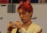 a young man with red hair wearing a teddy bear headband