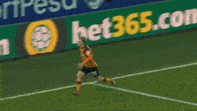 soccer players celebrate a goal in front of a bet365 banner