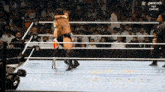 a wrestler is hugging another wrestler in a ring that says peacock next generation