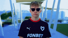 a man wearing sunglasses and a fonbet shirt