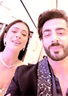 a man and a woman are posing for a picture .