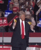 a man in a suit and tie is holding a sign that says trump exit
